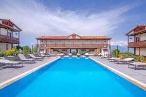 uma piscina com cadeiras e um edifício em Château Mosmieri Hotel & Winery em Telavi