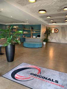 a lobby with aporate sign on a rug on the floor at The Originals City, Hôtel Ecoparc, Montpellier Est (Inter-Hotel) in Saint-Aunès