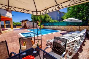 eine Terrasse mit einem Tisch und Stühlen sowie einem Pool in der Unterkunft Villa Anita in Pula