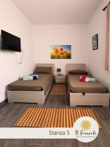 Habitación con 2 camas y TV. en IL GIRASOLE, en Porto Torres