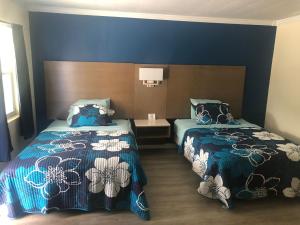 una camera con due letti e pareti blu di Salter Path Inn a Salter Path