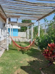 a hammock under a pergola in a yard at Kitnets Capri in Caraguatatuba