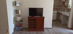 una televisione seduta su un supporto in legno in una stanza di Arétta: appartamento nel cuore di Itri a Itri