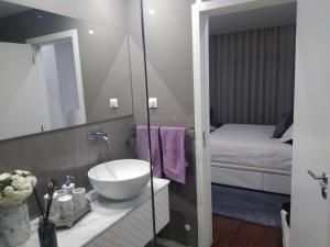 a bathroom with a sink and a bedroom with a bed at Luxury 3 Bedroom Penthouse With Private Garage in Braga +100 photos