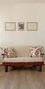 una panchina in una stanza con due cuscini di Arétta: appartamento nel cuore di Itri a Itri