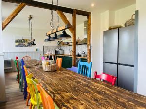 a kitchen with a wooden table and colorful chairs at Ferienhaus Backesgarten für 22 Personen in Neichen