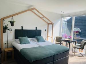 a bedroom with a large bed with a large window at B&B Bij tante Teun in Naaldwijk