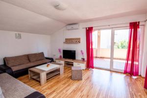 ein Wohnzimmer mit einem Sofa und einem TV in der Unterkunft Villa Anita in Pula