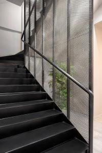 a set of black stairs with a black metal railing at Thisean Modern Suites By Athens Stay in Athens