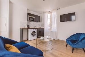 a living room with a blue couch and a table at REIMS - Place du Forum - Cathédrale - Terrasse in Reims