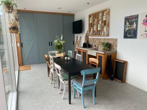 a dining room with a black table and chairs at B&B Bij tante Teun in Naaldwijk