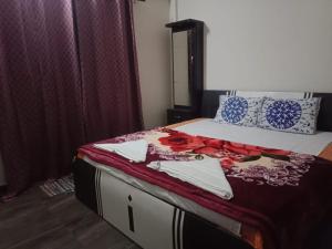 a bedroom with a bed with a red blanket on it at Casa Mount View villa wd pvt pool in Lonavala +14 photos