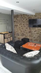 a black leather couch in a room with a table at La estrella del viajero in Casas del Abad