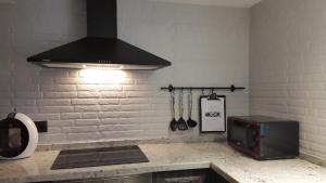 a kitchen with a counter with a stove and a microwave at La estrella del viajero in Casas del Abad