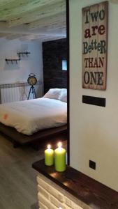 a bedroom with a bed and two candles on a table at La estrella del viajero in Casas del Abad