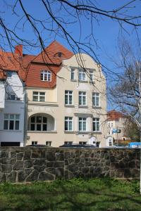 奥得河畔法兰克福Pension zum Kleistpark的一座红色屋顶的白色大楼