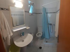 a bathroom with a sink and a toilet and a mirror at Zikas apartments in Marmari