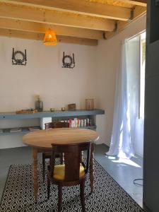 una sala da pranzo con tavolo e sedie in legno di Chambre d'hôtes La grange a Chalagnac