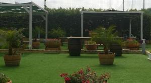 a garden with potted plants on the grass at Fiumara Del Sossio in Marsala