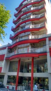 a tall apartment building with red columns at Hotel San Remo Majestic in Mar de Ajó