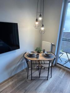 a dining room table with two chairs and a tv at Labar Apartments in Gdańsk