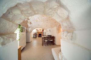 uma cozinha e sala de estar com uma parede de pedra em Trulli Girasoli e Viole em Cocolicchio
