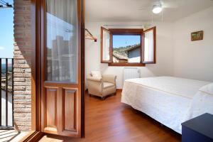 a bedroom with a bed and a chair and a window at Bellavista 2 in Alquézar