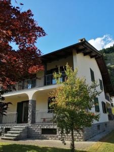 a large white building with a tree in front of it at B&B Carunei in Poggiridenti