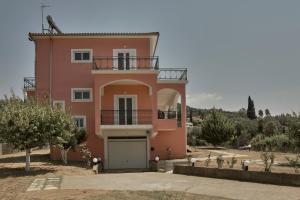 una casa rosa con balcone sopra di Villa Ancient Olympia by PCL a Pelópion