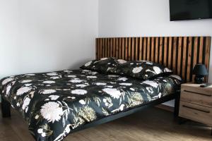 a bedroom with a bed with a black and white comforter at Pokoje Marysia Mechelinki in Mechelinki