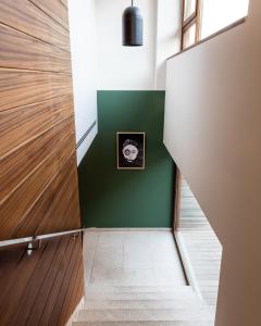 um corredor com paredes verdes e uma imagem na parede em No-Mad Green Hotel em Molinaseca