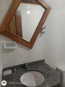 a bathroom with a sink and a mirror at Chalés do Apolinário in Tiradentes
