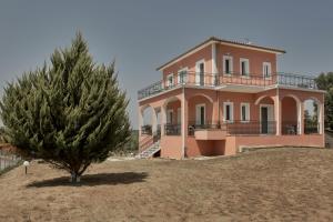 una casa su una collina con un albero davanti di Villa Ancient Olympia by PCL a Pelópion