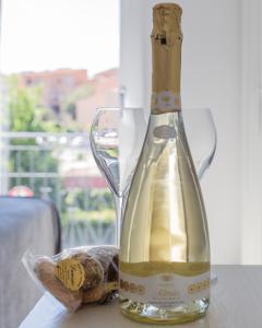 een fles wijn en een glas op een tafel bij J Rooms in Olbia
