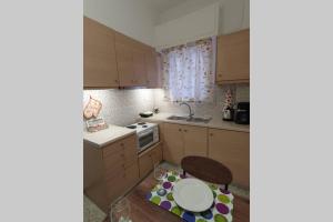 uma pequena cozinha com uma mesa e um lavatório em Greek hospitality in a modern apartment em Atenas