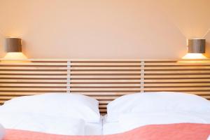 dos almohadas blancas sentadas en una cama con dos luces en Apartments Favoriten, en Viena