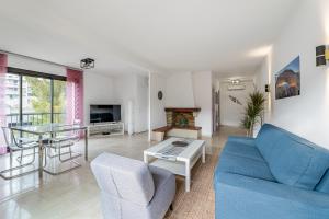 ein Wohnzimmer mit einem blauen Sofa und einem Tisch in der Unterkunft Leï Tapenié 2 par Dodo-a-Cassis in Cassis
