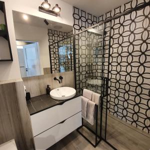 La salle de bains est pourvue d'un lavabo et d'un miroir. dans l'établissement Apartamenty Kąpielowa Biały, à Ełk