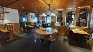 ein Restaurant mit Holzböden, Tischen und Stühlen in der Unterkunft Gasthof Hirschen in Wilderswil in Wilderswil
