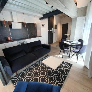 a living room with a couch and a table at Apartamenty Kąpielowa Biały in Ełk