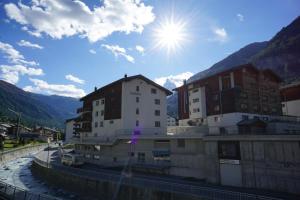 Eine Stadt mit Gebäuden und der Sonne am Himmel in der Unterkunft Haus Orta in Zermatt