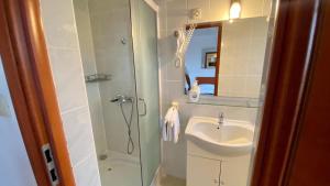 La salle de bains est pourvue d'un lavabo et d'une douche. dans l'établissement Villa Salyna, à Ičići