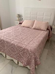 a bedroom with a large bed with a pink blanket at Apartamento Calle Nueva in Cádiz