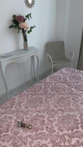カディスにあるApartamento Calle Nuevaのテーブルと花瓶がベッドに飾られた部屋