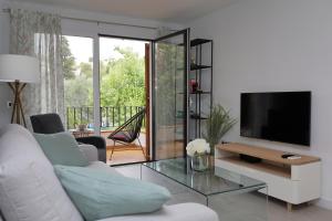 a living room with a tv and a couch and a table at Patricia's, lovely apartment in Port de Sóller in Port de Soller