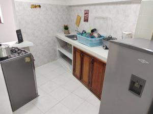 a small kitchen with a sink and a stove at Casa Paraguaná - tú espacio para el descanso in Santa Marta