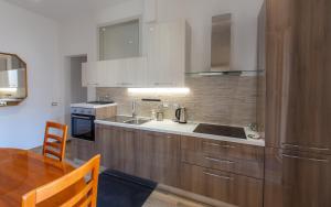 a kitchen with wooden cabinets and a wooden table with a dining room at TaoMau - Duomo Square in Taormina