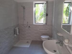 a white bathroom with a toilet and a sink at La Marina Bay in Vieste