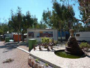 un parque con un banco y una fuente en Camping Torrenostra, en Torreblanca