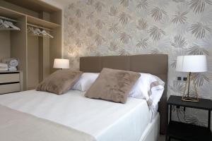 una camera con un letto bianco con due cuscini di Patricia's, lovely apartment in Port de Sóller a Port de Sóller
